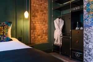 a bedroom with a bed and a brick wall at Velvet Hotel in Manchester