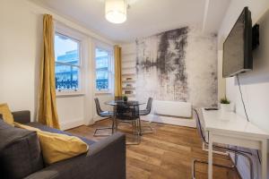uma sala de estar com um sofá e uma mesa em Oxford Street London by Threstle em Londres