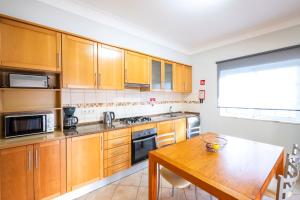 a kitchen with wooden cabinets and a wooden table at Villa Isa - Heated Pool - Free wi-fi - Air Con in Guia