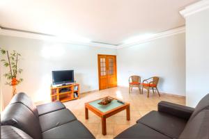 uma sala de estar com um sofá e uma televisão em Villa Isa - Heated Pool - Free wi-fi - Air Con na Guia