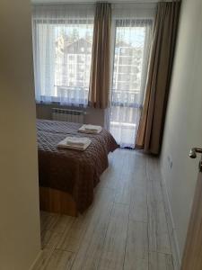 A bed or beds in a room at Borovets Gardens Apartment A27