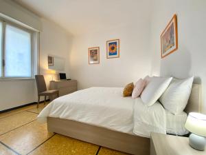 a bedroom with a white bed with a desk and a window at CasaViva- Ampio e luminoso quadrilocale a Rapallo in Rapallo