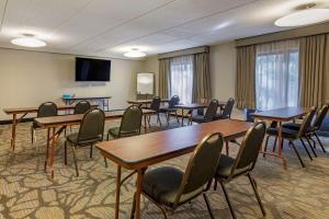 a conference room with tables and chairs and a screen at Comfort Suites Alpharetta-Roswell - Atlanta Area in Alpharetta