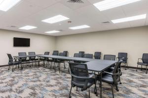 a conference room with tables and chairs and a tv at Sleep Inn & Suites Webb City 