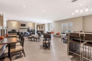 a restaurant with tables and chairs and a cafeteria at Sleep Inn & Suites Webb City 