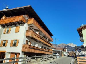 a building with wooden balconies on the side of it at Appartamento Casa Montagna Lory in Pozza di Fassa