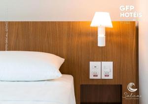 um quarto com uma cama e uma luz na parede em Apto no Salinas Exclusive Resort em Salinópolis