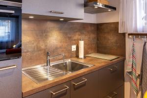 a kitchen with a sink and a counter top at studio ROSELINE - smart & modern in Grächen