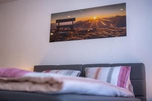 un soggiorno con divano e una foto appesa al muro di studio ROSELINE - smart & modern a Grächen