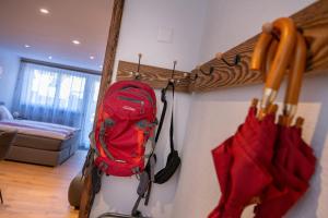 uno zaino rosso appeso a un muro in una stanza di studio ROSELINE - smart & modern a Grächen