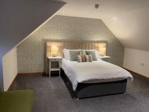 a bedroom with a large bed with two night stands at The Square Kintore in Kintore