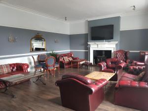 a living room with red furniture and a fireplace at Blue Bell Hotel in Belford