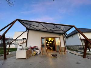 a pavilion with chairs and a couch on a patio at Nyúlászó Vendégház Stúdiólakás in Mád