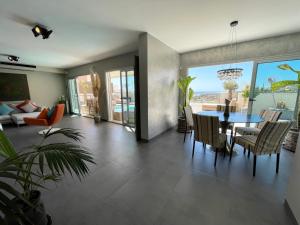uma sala de estar com uma mesa e uma sala de jantar em Luxury Villa Morelli with seaview & heated pool em Maspalomas