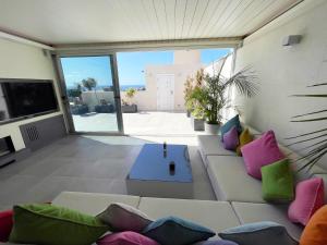 ein Wohnzimmer mit einem Sofa und bunten Kissen in der Unterkunft Luxury Villa Morelli with seaview & heated pool in Maspalomas