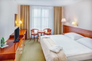 a hotel room with two beds and a desk at Spa & Wellness Hotel Olympia Marienbad in Mariánské Lázně