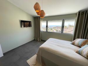 sypialnia z łóżkiem i dwoma oknami w obiekcie Luxury Villa Morelli with seaview & heated pool w mieście Maspalomas