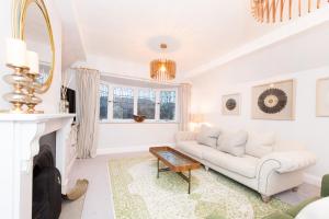 a living room with a white couch and a fireplace at The Tower by Harrogate Serviced Apartments in Harrogate