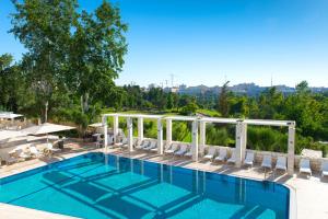 a swimming pool with white chairs at Leonardo Plaza Hotel Jerusalem in Jerusalem