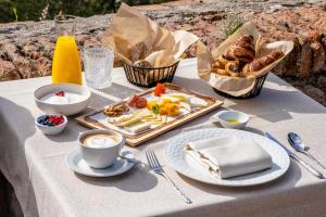 a table with a tray of food and coffee and pastries at Soho Boutique Castillo de Santa Catalina - Adults Recommended in Málaga