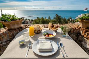 a table with a plate of food and a view of the ocean at Soho Boutique Castillo de Santa Catalina - Adults Recommended in Málaga