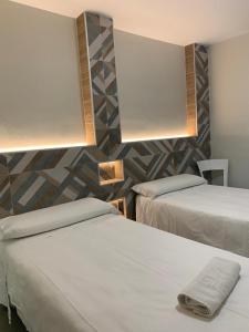 Un ou plusieurs lits dans un hébergement de l'établissement Hostal Acemar