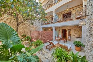 an outdoor patio with plants and a building at Cas Comte Suites & Spa - Adults Only in Lloseta
