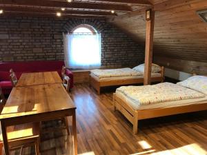 een kamer met 2 bedden, een tafel en een raam bij Cifrapince és Vendégház in Tordas