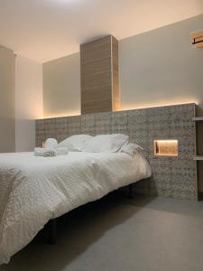 une chambre avec un grand lit avec des oreillers blancs dans l'établissement Hostal Acemar, à Marbella