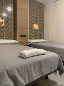 - une chambre avec 2 lits et des serviettes blanches sur le lit dans l'établissement Hostal Acemar, à Marbella