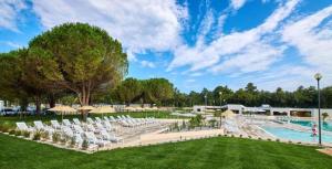 a pool with white lounge chairs and a pool at Easyatent Camping Stella Maris in Umag