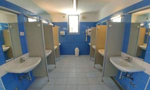 a bathroom with two sinks and blue walls at Easyatent Camping Stella Maris in Umag