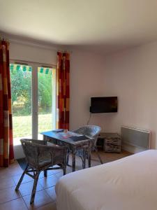 a room with a table and a tv and a bed at Golf Hotel de la Carte in Chouzy-sur-Cisse