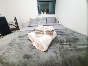 a bedroom with a bed with towels on it at LiveStay-Modern 3 Bed Apt on 8th Floor with Amazing Views in London