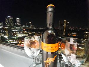 a bottle of wine sitting next to two wine glasses at LiveStay-Modern 3 Bed Apt on 8th Floor with Amazing Views in London