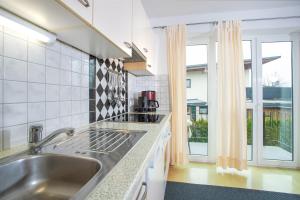 eine Küche mit einem Waschbecken und einem großen Fenster in der Unterkunft Zillertal Appartements in Fügen