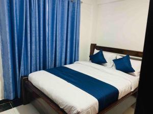 a bedroom with a bed with blue curtains at EM's Place Bridge View Furnished Apartments Naivasha in Naivasha