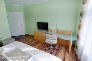 een slaapkamer met een bureau en een bed en een bureau met een computer bij Aparthotel Katowice in Katowice