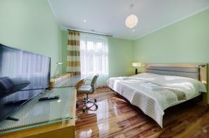 Dormitorio con cama, escritorio y TV en Aparthotel Katowice en Katowice
