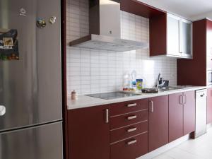 cocina con armarios morados y nevera de acero inoxidable en G g spacious bungalow in maspalomas, en Sonnenland