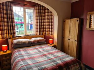 um quarto com uma cama com 2 candeeiros e uma janela em Tudor Lodge Hotel em Nottingham