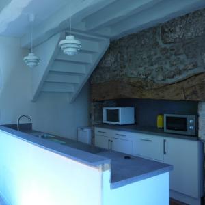 ValeillesにあるGîte l'Odonataの石壁のキッチン(白いキャビネット付)