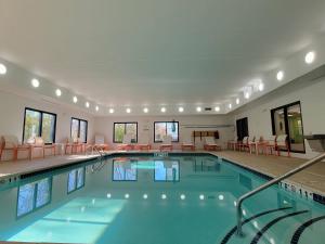 una gran piscina con sillas y mesas en Holiday Inn Hotel & Suites Ann Arbor University of Michigan Area, an IHG Hotel, en Ann Arbor