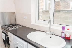 a kitchen with a sink and a stove at Hanley Park House in Stoke on Trent