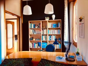 een kamer met een bureau en een boekenplank met boeken bij Appartamento tra Monza e Milano in Muggiò