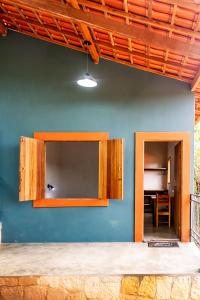 a room with a blue wall with wooden cabinets at Refugio no meio da natureza no Vale do Capao-BA in Vale do Capao