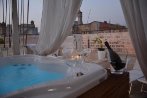 una vasca da bagno con bicchieri da vino su un balcone di Vico degli Ebrei - Rooftop Jacuzzi - self check-in a Leverano