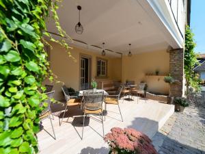 un patio con sillas, una mesa y una pared de ladrillo en Gästehaus & Weingut GEHRIG en Weisenheim am Sand