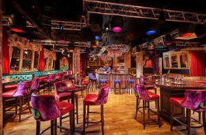 a bar with purple chairs and tables in a room at The Grafton Hotel in Dublin