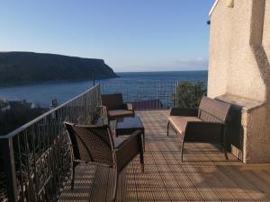 balcón con sillas, mesa y vistas al océano en Sunnyside House, en Gardenstown